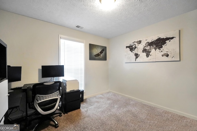 carpeted office space with baseboards and a textured ceiling