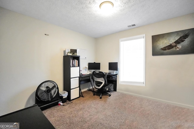 carpeted office featuring a textured ceiling and baseboards