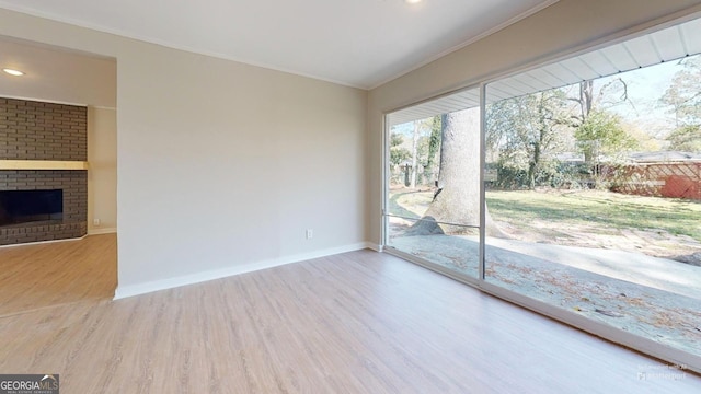 2280 Raleigh Dr, Augusta, GA 30904 - spare room featuring wood finished floors, crown molding, baseboards, recessed lighting, and a brick fireplace
