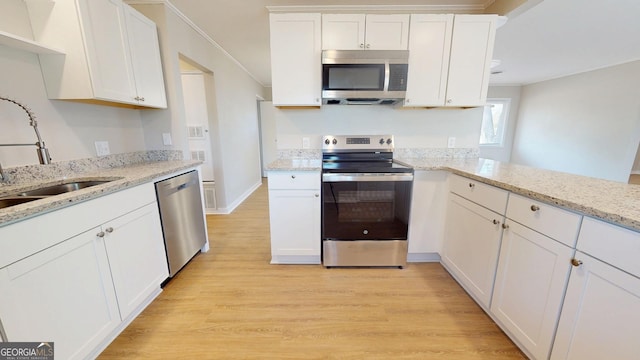2280 Raleigh Dr, Augusta, GA 30904 - kitchen with appliances with stainless steel finishes, light wood finished floors, white cabinets, a sink, and ornamental molding