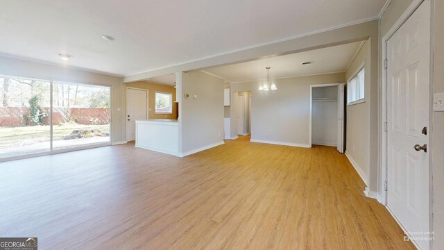 2280 Raleigh Dr, Augusta, GA 30904 - unfurnished living room featuring a chandelier, light wood finished floors, crown molding, and baseboards