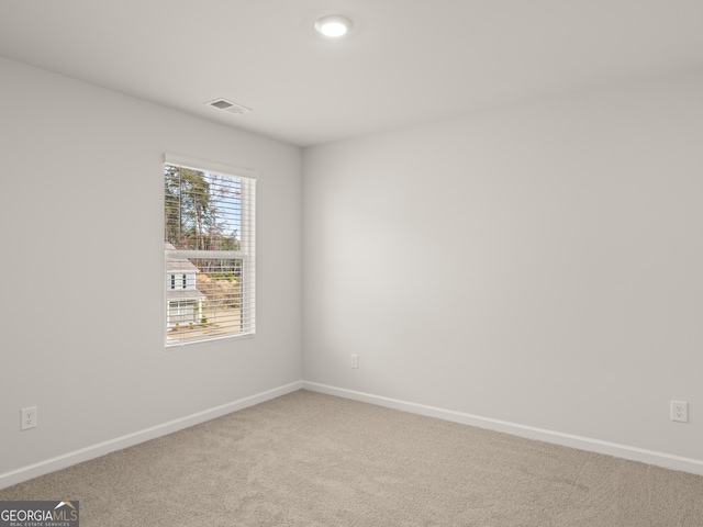 spare room with baseboards and carpet floors