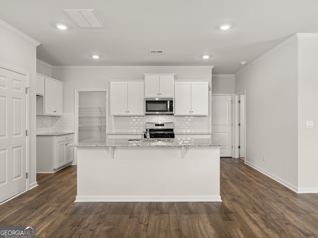 kitchen featuring stainless steel appliances, tasteful backsplash, crown molding, white cabinets, and recessed lighting