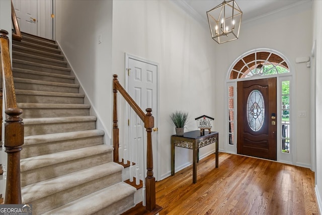 1444 Merrifield Ln, Marietta, GA 30062 - entrance foyer featuring a towering ceiling, stairs, a chandelier, ornamental molding, and wood finished floors