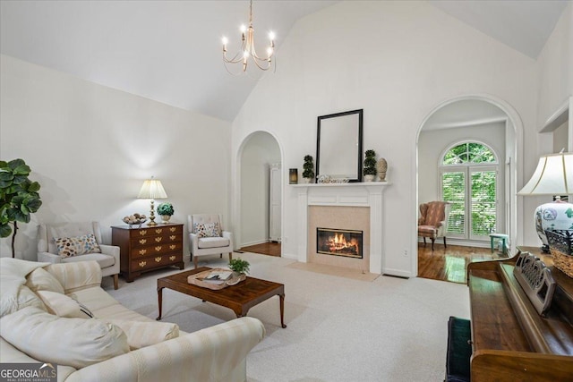 1444 Merrifield Ln, Marietta, GA 30062 - carpeted living area featuring arched walkways, high vaulted ceiling, a tile fireplace, and a chandelier