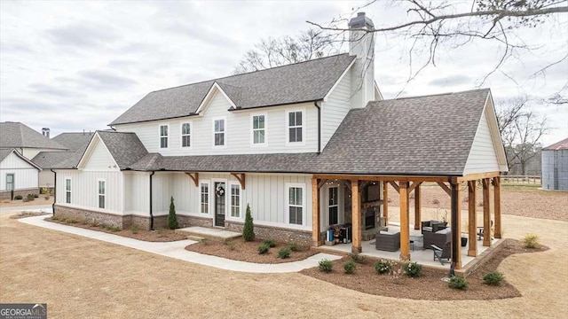 1325 Silo Bnd, Watkinsville, GA 30677 - modern farmhouse with board and batten siding, a patio, roof with shingles, a chimney, and outdoor lounge area