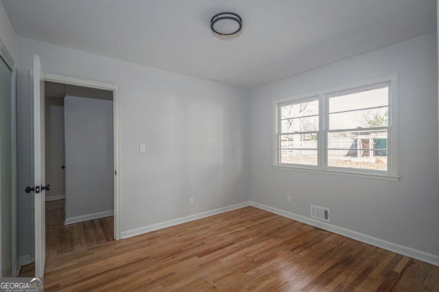 empty room featuring wood finished floors and baseboards