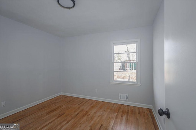 spare room featuring wood finished floors and baseboards