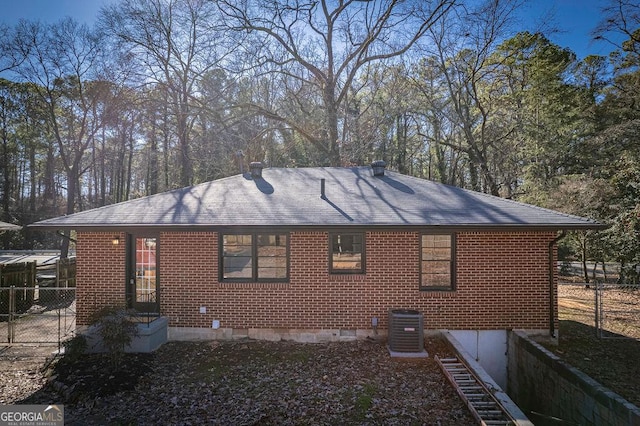 rear view of property featuring cooling unit and brick siding