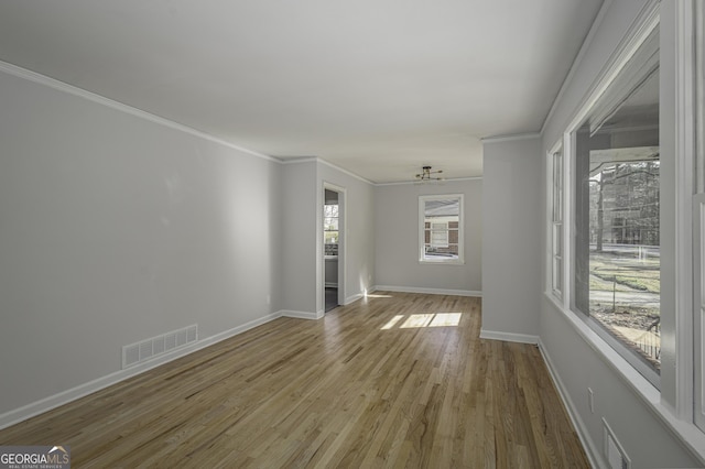 spare room with wood finished floors, ornamental molding, and baseboards