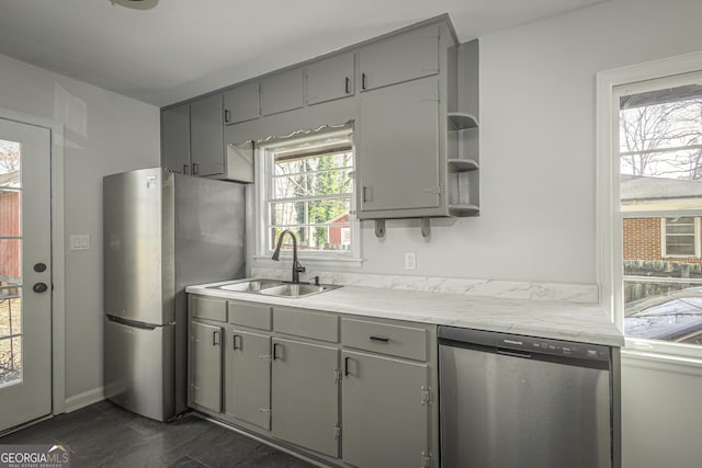 kitchen with stainless steel appliances, gray cabinets, a sink, and open shelves