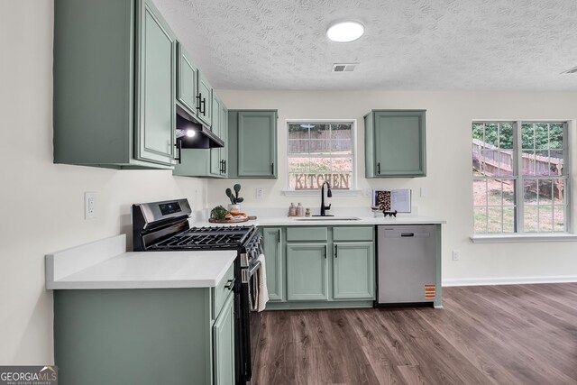 1075 Litchfield Way SW, Marietta, GA 30060 - kitchen featuring green cabinets, appliances with stainless steel finishes, a sink, under cabinet range hood, and a textured ceiling