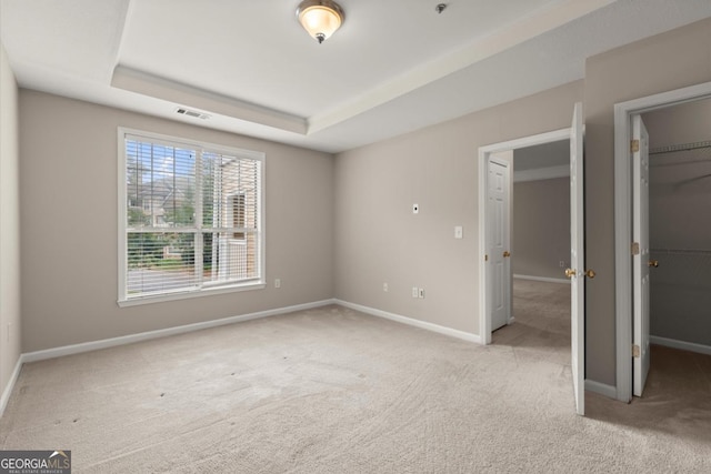 426 Pembrooke Cir Unit 426, Alpharetta, GA 30004 - unfurnished bedroom featuring carpet flooring, a spacious closet, a tray ceiling, and a closet