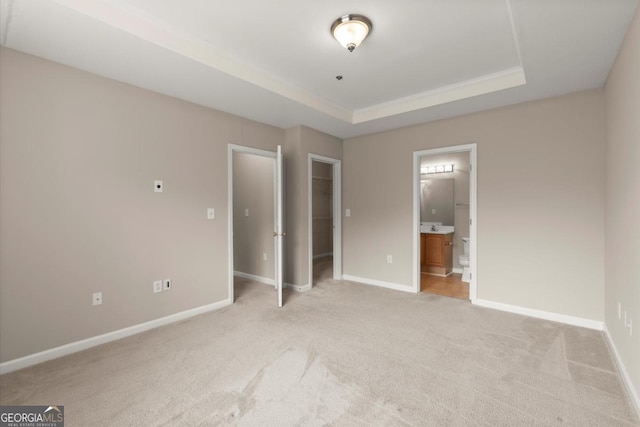 426 Pembrooke Cir Unit 426, Alpharetta, GA 30004 - unfurnished bedroom with light colored carpet, a walk in closet, a raised ceiling, connected bathroom, and a closet