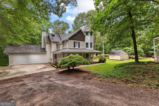 view of front of property featuring driveway, an attached garage, a chimney, and a front yard