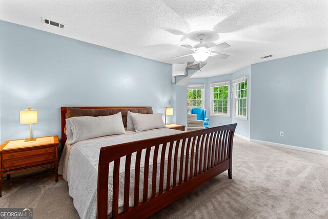 bedroom with carpet, a textured ceiling, baseboards, and ceiling fan
