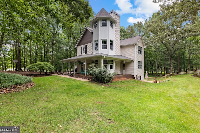 view of front facade featuring a chimney, a front lawn, a porch, and roof with shingles