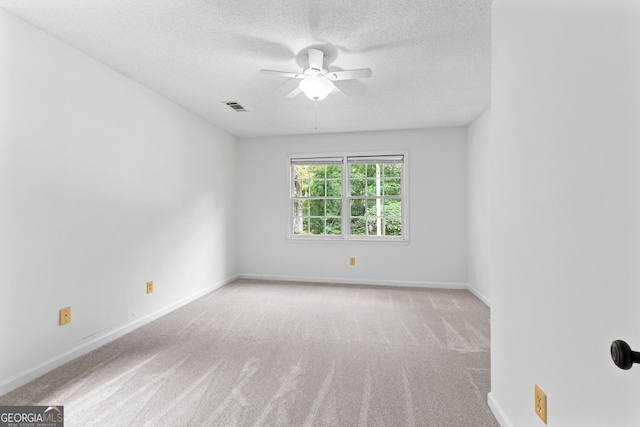carpeted empty room with ceiling fan, a textured ceiling, and baseboards