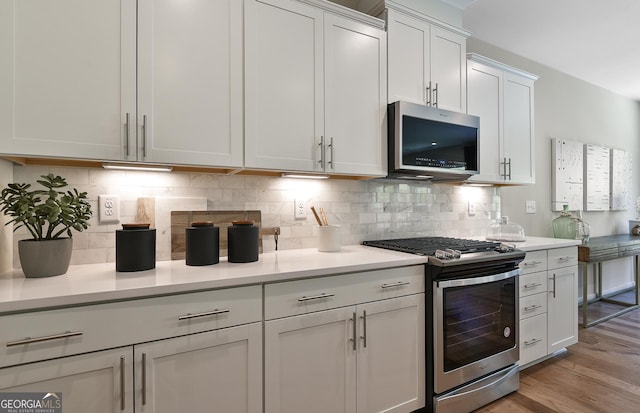 4297 Azalea Ridge Way, Hoschton, GA 30548 - kitchen featuring stainless steel appliances, light countertops, light wood-type flooring, and decorative backsplash