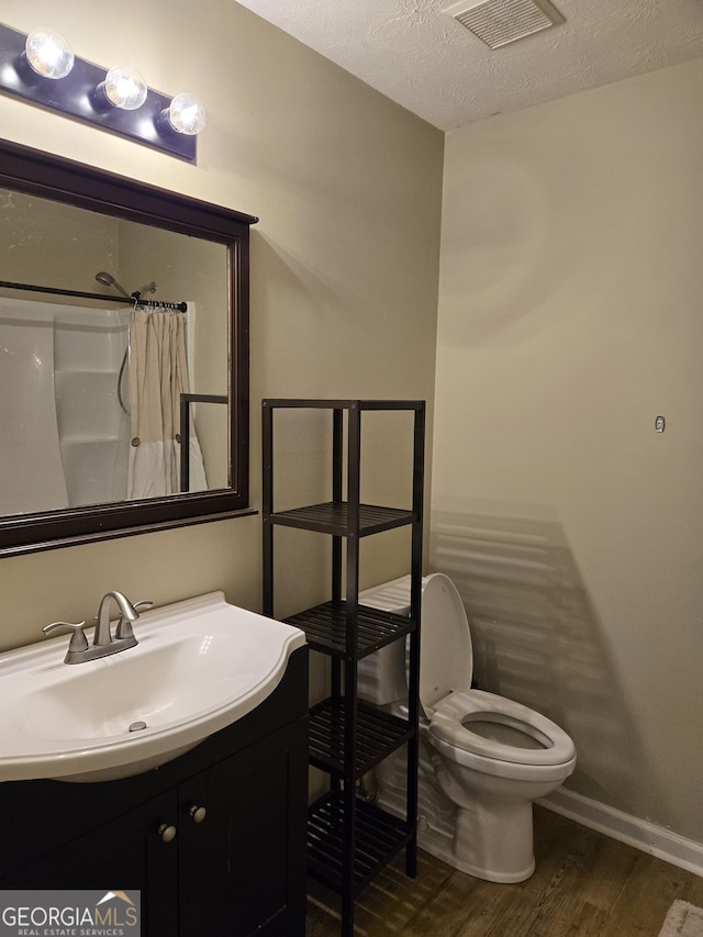 full bathroom with wood finished floors, toilet, vanity, baseboards, and curtained shower