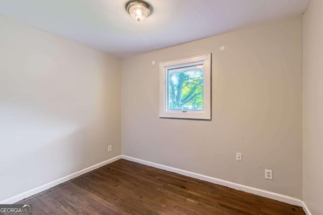 empty room with baseboards and dark wood-style flooring