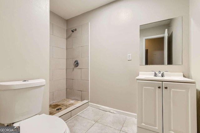 full bathroom with toilet, tile patterned floors, tiled shower, vanity, and baseboards