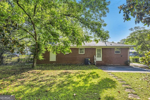 rear view of house featuring entry steps, brick siding, and central air condition unit