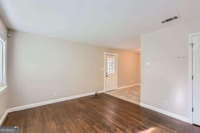 spare room featuring wood finished floors and baseboards