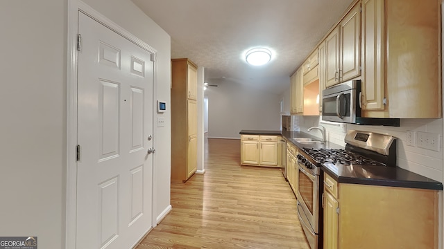200 Compton Ct, Mcdonough, GA 30252 - kitchen featuring stainless steel appliances, a sink, dark countertops, light wood-style flooring, and backsplash