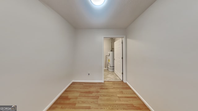 200 Compton Ct, Mcdonough, GA 30252 - unfurnished room with water heater, light wood-style flooring, and baseboards