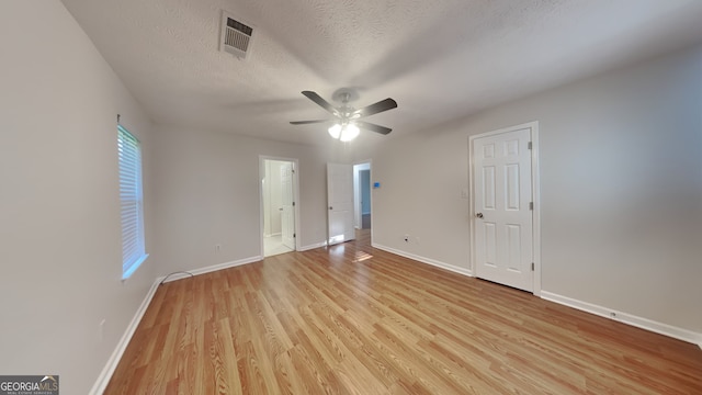 200 Compton Ct, Mcdonough, GA 30252 - unfurnished bedroom featuring light wood finished floors, baseboards, a textured ceiling, a ceiling fan, and connected bathroom