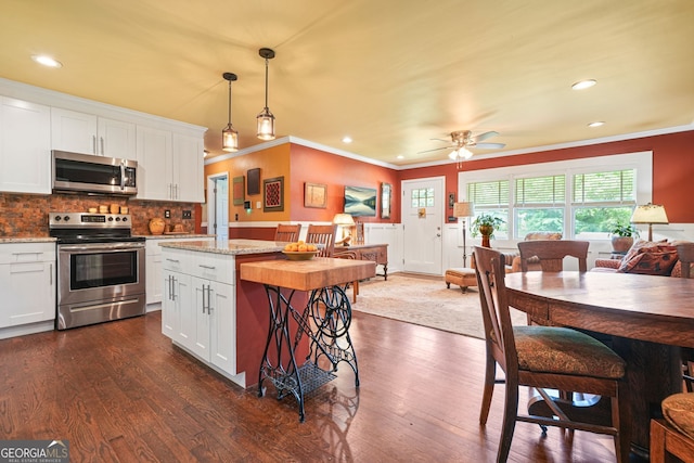 3839 Brookcrest Cir, Decatur, GA 30032 - kitchen with appliances with stainless steel finishes, ornamental molding, dark wood finished floors, white cabinets, and tasteful backsplash