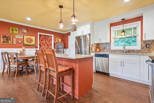 3839 Brookcrest Cir, Decatur, GA 30032 - kitchen featuring stainless steel appliances, ornamental molding, a kitchen island, white cabinetry, and backsplash