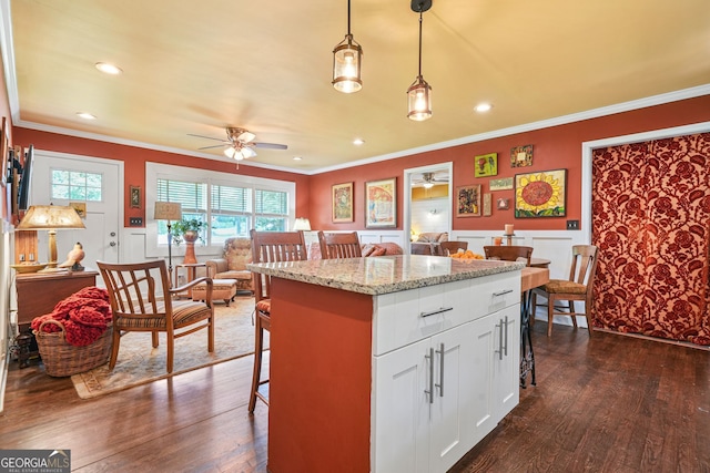3839 Brookcrest Cir, Decatur, GA 30032 - kitchen with ceiling fan, a breakfast bar area, crown molding, open floor plan, and dark wood finished floors