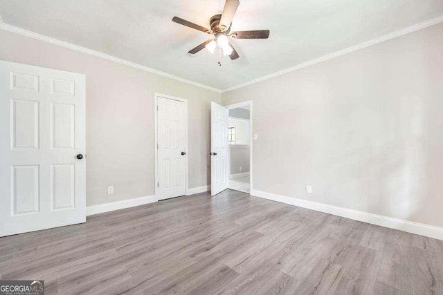 unfurnished bedroom featuring wood finished floors, ornamental molding, baseboards, a ceiling fan, and a closet
