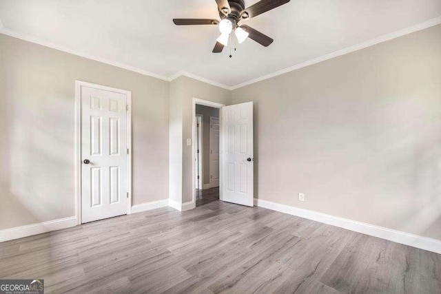 unfurnished bedroom with wood finished floors, baseboards, crown molding, and a ceiling fan