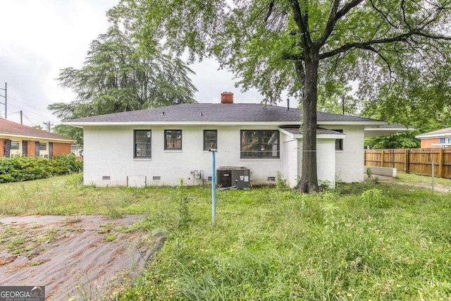 rear view of house featuring crawl space, cooling unit, a chimney, brick siding, and roof with shingles