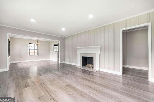 unfurnished living room featuring ornamental molding, a fireplace with flush hearth, baseboards, wood finished floors, and recessed lighting