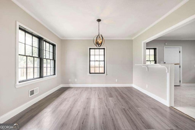 unfurnished dining area featuring a chandelier, baseboards, wood finished floors, and ornamental molding