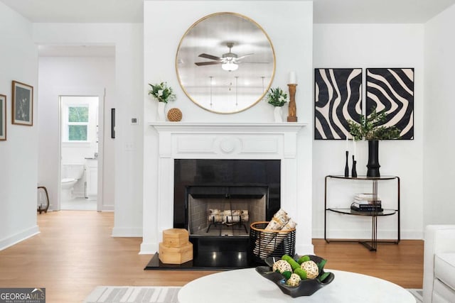 3390 Traditions Way, Jefferson, GA 30549 - living area featuring wood finished floors, a ceiling fan, a fireplace with flush hearth, and baseboards