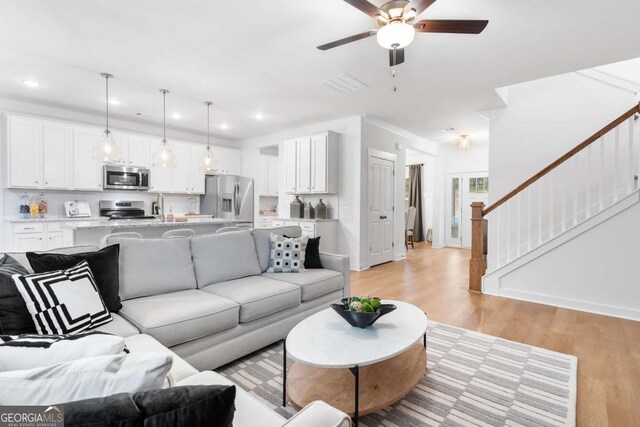 3390 Traditions Way, Jefferson, GA 30549 - living room featuring light wood-style flooring, ceiling fan, stairs, recessed lighting, and baseboards