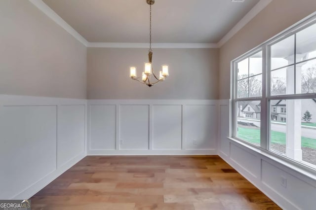3354 Traditions Way, Jefferson, GA 30549 - unfurnished dining area featuring a decorative wall, plenty of natural light, a chandelier, ornamental molding, and light wood-style flooring