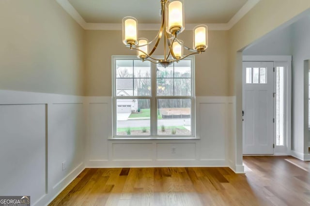 3354 Traditions Way, Jefferson, GA 30549 - unfurnished dining area featuring a decorative wall, a chandelier, a wainscoted wall, wood finished floors, and ornamental molding