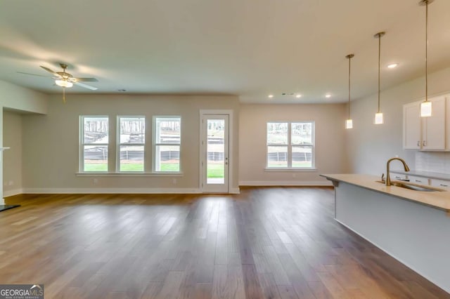 3354 Traditions Way, Jefferson, GA 30549 - unfurnished living room featuring a sink, baseboards, dark wood-style flooring, ceiling fan, and recessed lighting