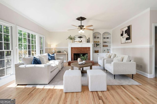 4711 Oakleigh Manor Dr, Powder Springs, GA 30127 - living room with built in features, wood finished floors, a ceiling fan, crown molding, and a fireplace