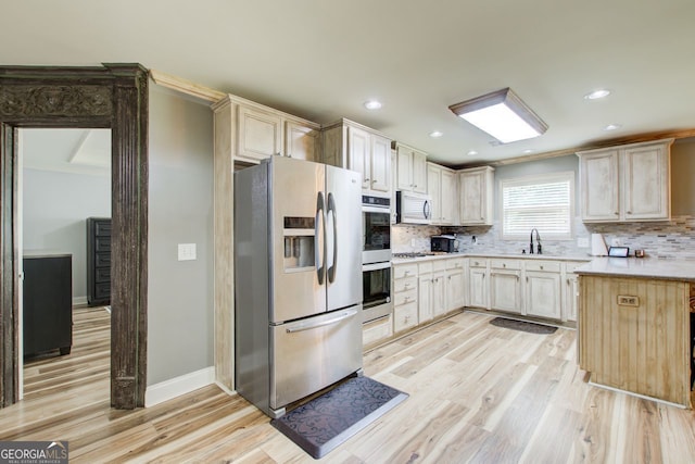5220 Wild Cedar Dr, Buford, GA 30518 - kitchen with appliances with stainless steel finishes, light wood-type flooring, decorative backsplash, light countertops, and a sink