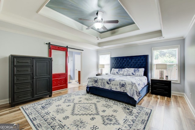 5220 Wild Cedar Dr, Buford, GA 30518 - bedroom featuring a tray ceiling, a barn door, ornamental molding, light wood finished floors, and baseboards