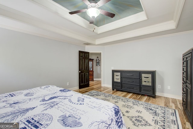 5220 Wild Cedar Dr, Buford, GA 30518 - bedroom featuring a raised ceiling, light wood finished floors, ornamental molding, a ceiling fan, and baseboards