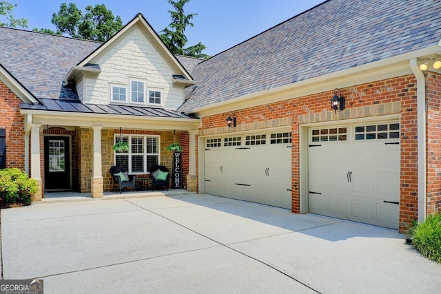 5220 Wild Cedar Dr, Buford, GA 30518 - view of property exterior featuring driveway, a standing seam roof, roof with shingles, covered porch, and an attached garage