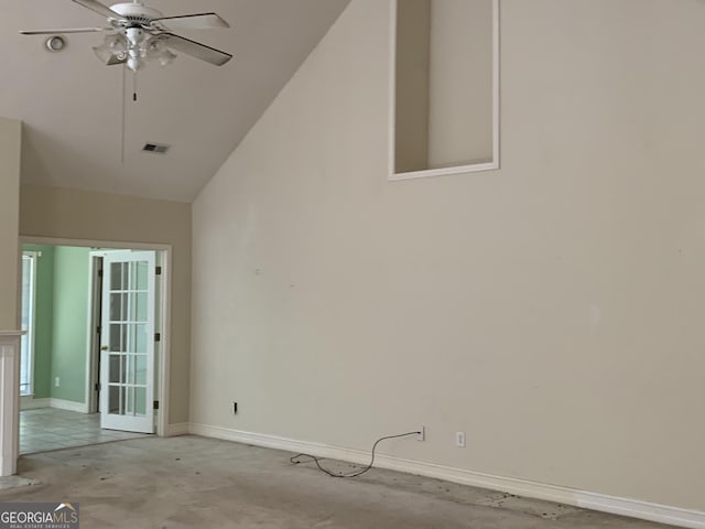 spare room featuring ceiling fan, baseboards, concrete floors, and vaulted ceiling